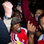 Ian Wright oslavuje s fanúšikmi na Emirates Stadium, keď Arsenal získal titul v Premier League.