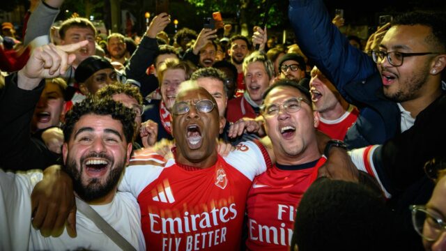 Ian Wright oslavuje s fanúšikmi na Emirates Stadium, keď Arsenal získal titul v Premier League. 