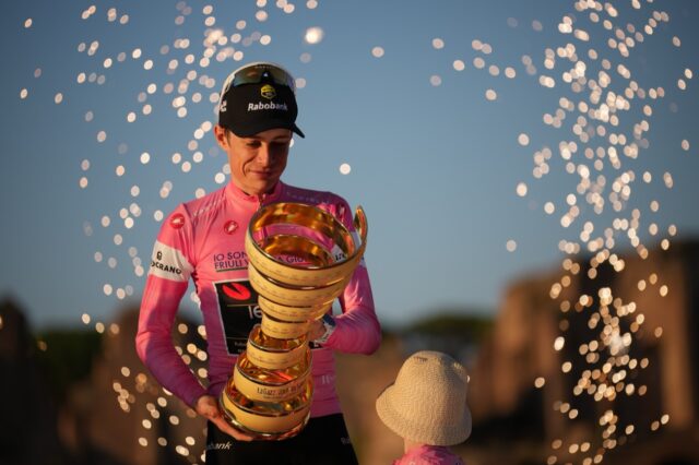 Prvý umiestnený Dánsko Jonas Vingegaard drží trofej, keď oslavuje na pódiu na konci cyklistických pretekov Giro d'Italia v Ríme nedeľu 31. mája 2026. (AP Photo/Andrew Medichini)