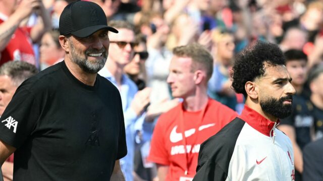 Nemecký manažér Liverpoolu Jurgen Klopp (L) odchádza s egyptským útočníkom Liverpoolu #11 Mohamedom Salahom (C) pred výkopom zápasu anglickej Premier League medzi Liverpoolom a Wolverhampton Wanderers na Anfielde v Liverpoole v severozápadnom Anglicku 19. mája 2024.