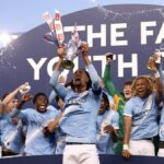 MANCHESTER, ANGLICKO - 14. MÁJ: Kaden Braithwaite z Manchestru City zdvihol nad hlavu trofej FA Youth Cup po víťazstve tímu vo finálovom zápase FA Youth Cup medzi Manchestrom City a Manchestrom United na Joie Stadium 14. mája 2026 v Manchestri v Anglicku. (Foto: Naomi Baker/Getty Images)