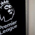 Sean Dyche stojí pred dodávkou s prekríženými rukami a usmieva sa. Na dodávke je napísané: „Nadýchnite sa, VAR von“.