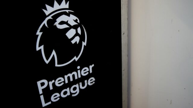   Sean Dyche stojí pred dodávkou s prekríženými rukami a usmieva sa. Na dodávke je napísané: „Nadýchnite sa, VAR von“.