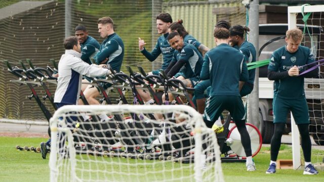 Declan Rice z Arsenalu (uprostred) sa počas tréningu v Sobha Realty Training Centre v Londýne rozcvičuje na bicykli s tímovými kolegami.