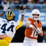 31. decembra 2025; Orlando, FL, USA; Obranný líder Michigan Wolverines Damon Payne (44) tipuje prihrávku rozohrávača Texas Longhorns Archa Manninga (16) počas prvého polčasu na Camping World Stadium. Povinný kredit: Matt Pendleton-Imagn Images