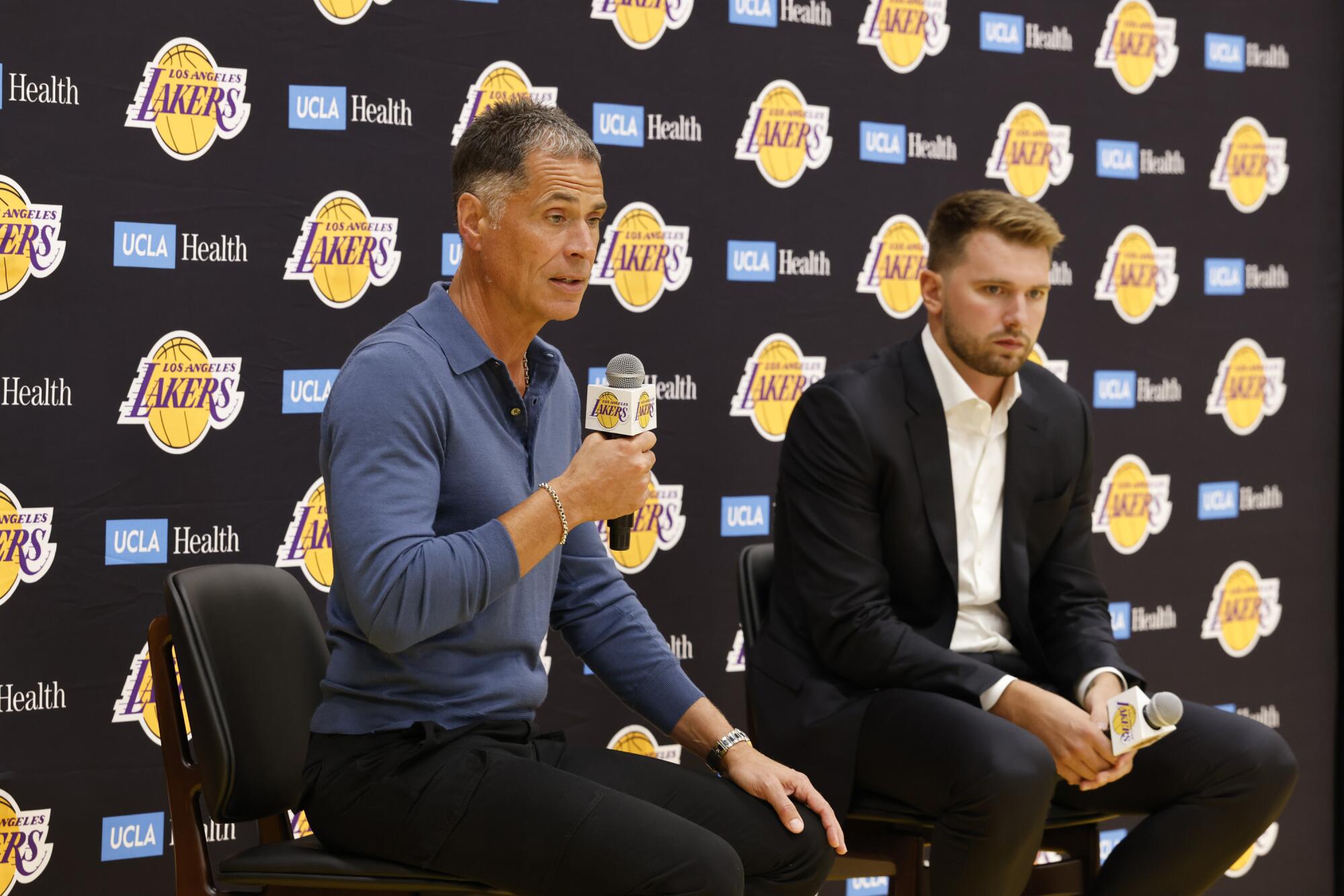 GM Lakers Rob Pelinka (vľavo) hovorí s novinármi počas úvodnej tlačovej konferencie pre Luku Dončiča (vpravo).