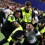 Americkí stewardi riešia fanúšika po invázii na ihrisku počas zápasu Svetového pohára medzi Iránom a Egyptom
