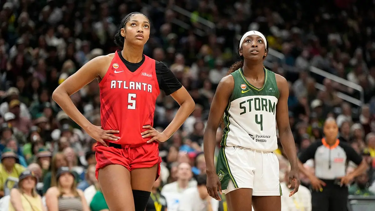 Flau'jae Johnson a Angel Reese stojaci na basketbalovom ihrisku počas hry