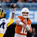 Obranný obranca Michigan Wolverines Damon Payne tipuje prihrávku rozohrávača Texas Longhorns Archa Manninga na Camping World Stadium