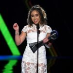Katelyn Ohashi gestikuluje jednou rukou a v druhej drží trofej, keď preberá cenu ESPY