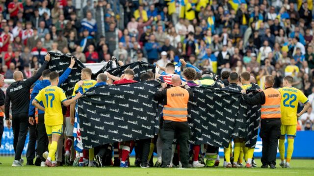 Hráči Dánska a Ukrajiny sprevádzajú Christiana Eriksena do čakacej ambulancie 