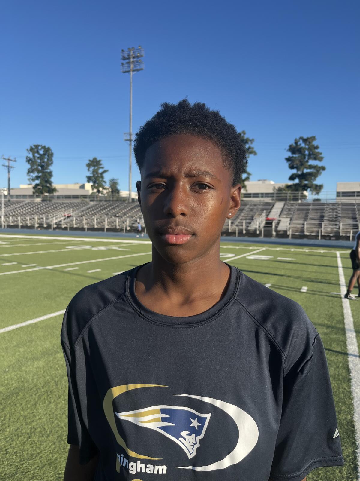 Prvý rozohrávač Exavier Johnson z Birmingham High pózuje na fotke na futbalovom ihrisku.