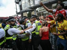Deväť ľudí bolo zatknutých na prehliadke titulu Premier League v severnom Londýne, keď po prehre v Lige majstrov vypukol chaos Fanúšikovia Rowdyho Arsenalu v konfrontácii s policajtmi, keď na nich jeden priaznivec kladie prostredníky