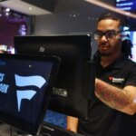 Člen tímu stojaci vo Fanatics Sportsbook v Ocean Casino Resort v Atlantic City, New Jersey.