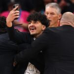 Fanúšik beží na kurt a snaží sa urobiť si selfie s Wembanyamom počas výhry Knicks
