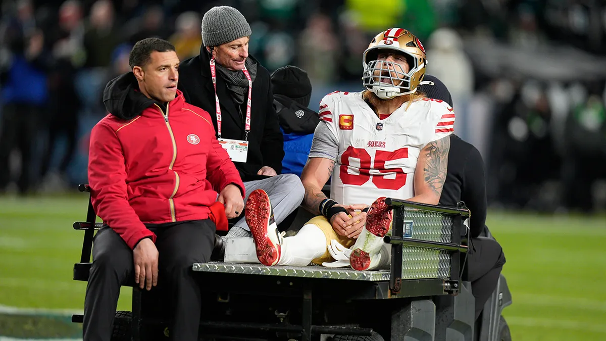 Pevný George Kittle zo San Francisca 49ers sediaci na vozíku na futbalovom ihrisku.