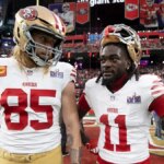 George Kittle a Brandon Aiyuk stojaci na ihrisku Allegiant Stadium v ​​Las Vegas.