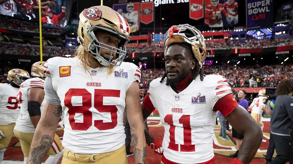 George Kittle a Brandon Aiyuk stojaci na ihrisku Allegiant Stadium v ​​Las Vegas.