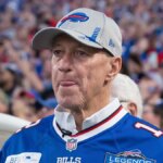 Jim Kelly stojaci na ihrisku Highmark Stadium pred zápasom.