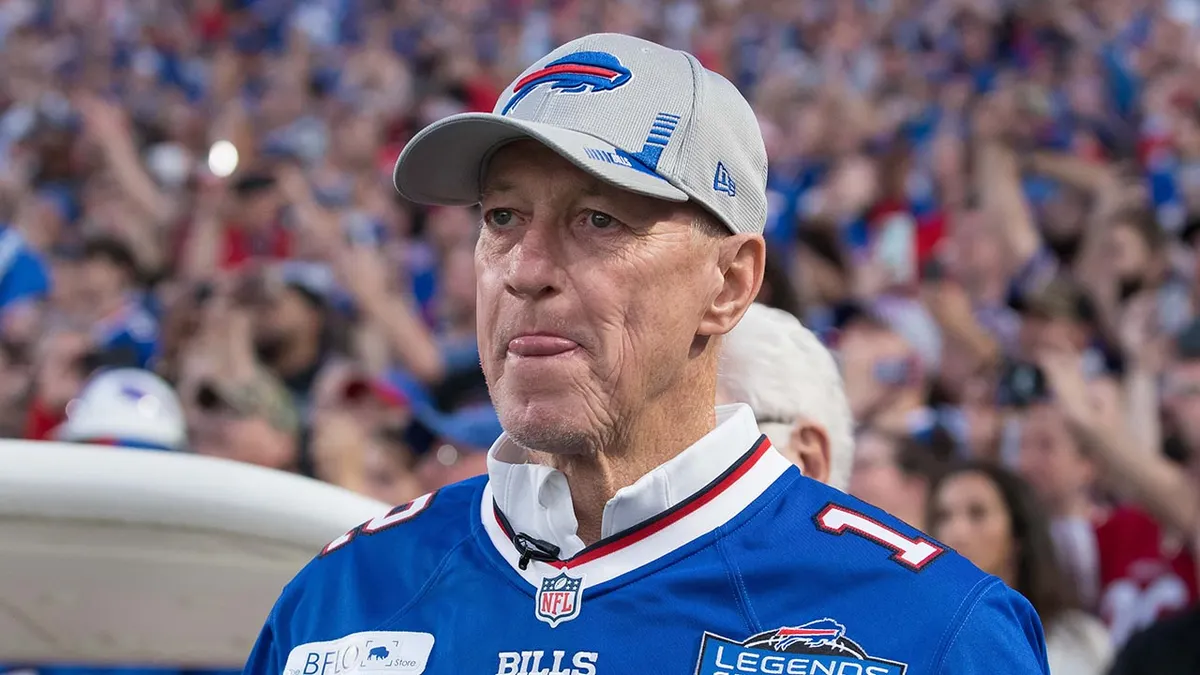 Jim Kelly stojaci na ihrisku Highmark Stadium pred zápasom.