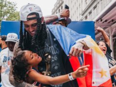 Jordan Clarkson hrdo nesie filipínsku vlajku na Knicks parade Jordan Clarkson, zahalený filipínskou vlajkou, pózuje na fotografii so svojou dcérou počas prehliadky majstrovstiev NBA v New Yorku Knicks.