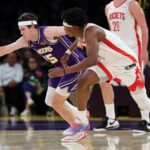Strážca Lakers Austin Reaves (vľavo) siaha pravou rukou po uvoľnenej lopte pred strážcom Rockets Amenom Thompsonom (vpravo).