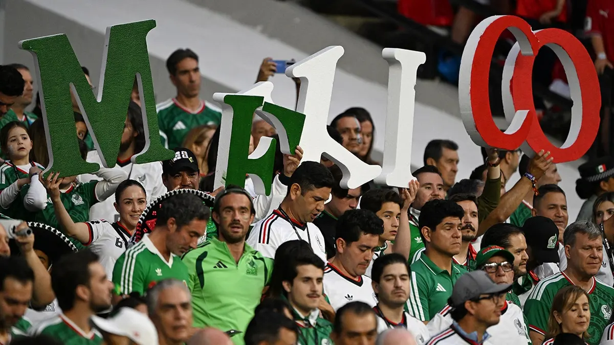 Mexickí fanúšikovia držiaci listy s nápisom Mexiko povzbudzujúc na futbalovom štadióne.