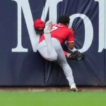 Dane Myers z Cincinnati Reds narazil do steny po chytení počas bejzbalového zápasu.