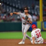 23. júna 2026; Anaheim, Kalifornia, USA; Tretí hráč Los Angeles Angels Donovan Walton (35) je na druhom mieste, keď druhý hráč tímu Baltimore Orioles Jeremiah Jackson (82) hádže na prvé miesto v zápase proti pravému hráčovi v poli Jo Adell (7) počas ôsmej zmeny na Angel Stadium. Povinný kredit: Gary A. Vasquez-Imagn Images