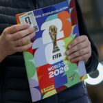 Osoba oblečená v tmavom saku drží farebnú brožúru s logom Majstrovstiev sveta vo futbale 2026.