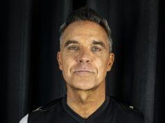 Robbie Williams robí Ryana Reynoldsa! Hitmaker Angels sa pripája k slávnemu futbalovému vlaku, keď čerpá peniaze na sponzorovanie svojho chlapčenského tímu Robbie Williams si obliekol novú súpravu Port Vale so zlatým logom vpredu a v strede