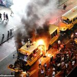 Roztrhaný školský autobus, ktorý začína horieť neďaleko Times Square, stoja na roztrhanom školskom autobuse