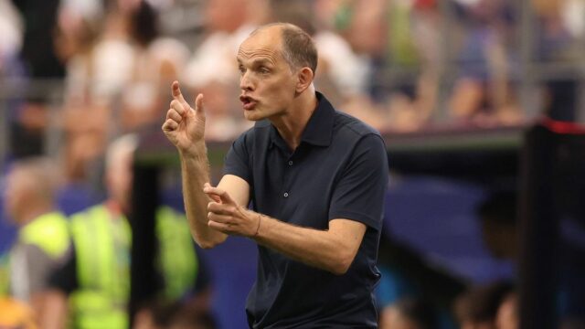 Thomas Tuchel by mohol podniknúť veľkolepý hazard v Anglicku s Futbalista v žltom drese kľačí na ihrisku, pravdepodobne v súťažnom zápase, s divákmi v pozadí.