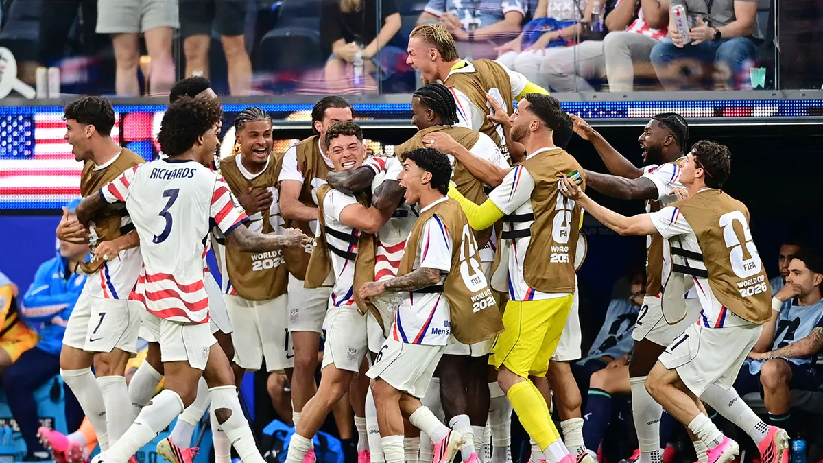 Folarin Balogun z USA oslavuje so spoluhráčmi na futbalovom ihrisku.