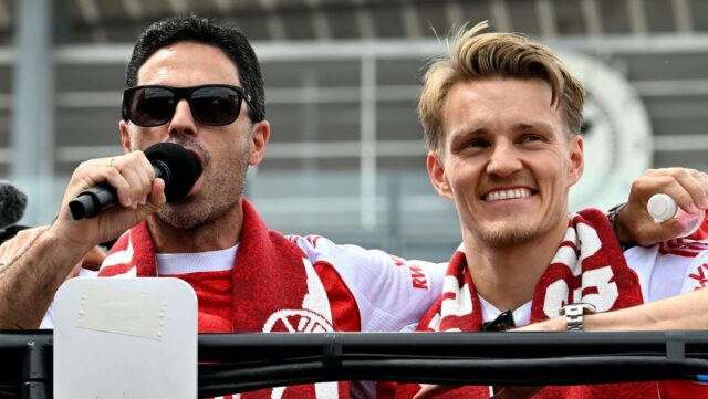 Mikel Arteta, manažér Arsenalu, a Martin Odegaard z Arsenalu sa rozprávajú s fanúšikmi počas oslavy v autobuse s otvorenou strechou