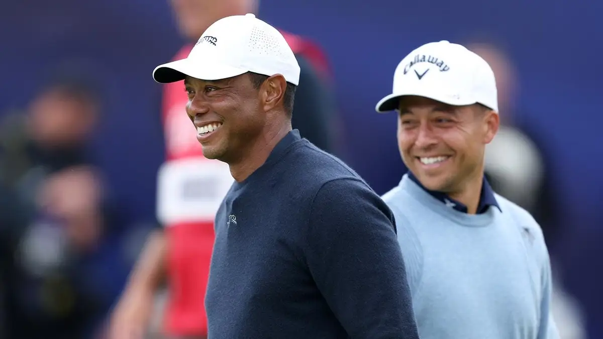Tiger Woods a Xander Schauffele reagujú na 18. greene v Royal Troon.