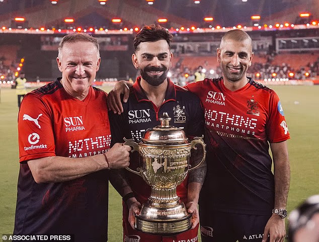 Andy Flower (vľavo) s Viratom Kohlim a riaditeľom kriketu Mo Bobatom ako Royal Challengers Bangalore pozdvihli titul indickej Premier League 2026