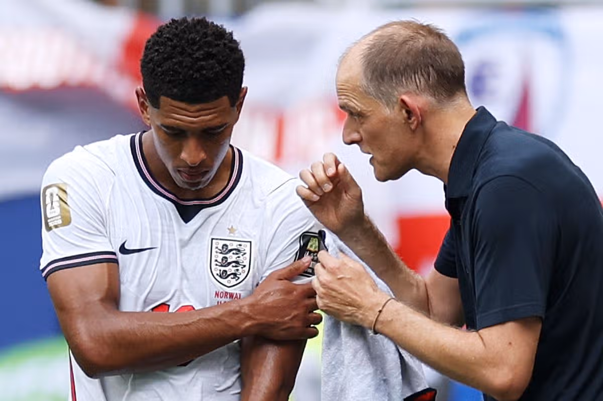 Jude Bellingham #10 z Anglicka sa drží za rameno, keď hovorí s Thomasom Tuchelom, manažérom Anglicka, počas štvrťfinálového zápasu FIFA World Cup 2026 medzi Nórskom a Anglickom na štadióne Miami 11. júla 2026 v Miami Gardens na Floride.