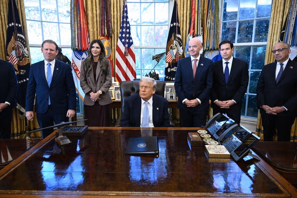 K americkému prezidentovi Donaldovi Trumpovi (C) sa pripája (LR) výkonný riaditeľ pracovnej skupiny Bieleho domu pre Majstrovstvá sveta vo futbale 2026