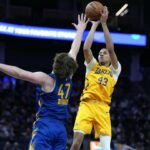 Nováčik Lakers Cameron Carr strieľa trojkou cez Lachlana Olbricha z Golden State.