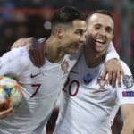 Cristiano Ronaldo (vľavo) oslavuje gól s rukou okolo portugalského spoluhráča Dioga Jotu