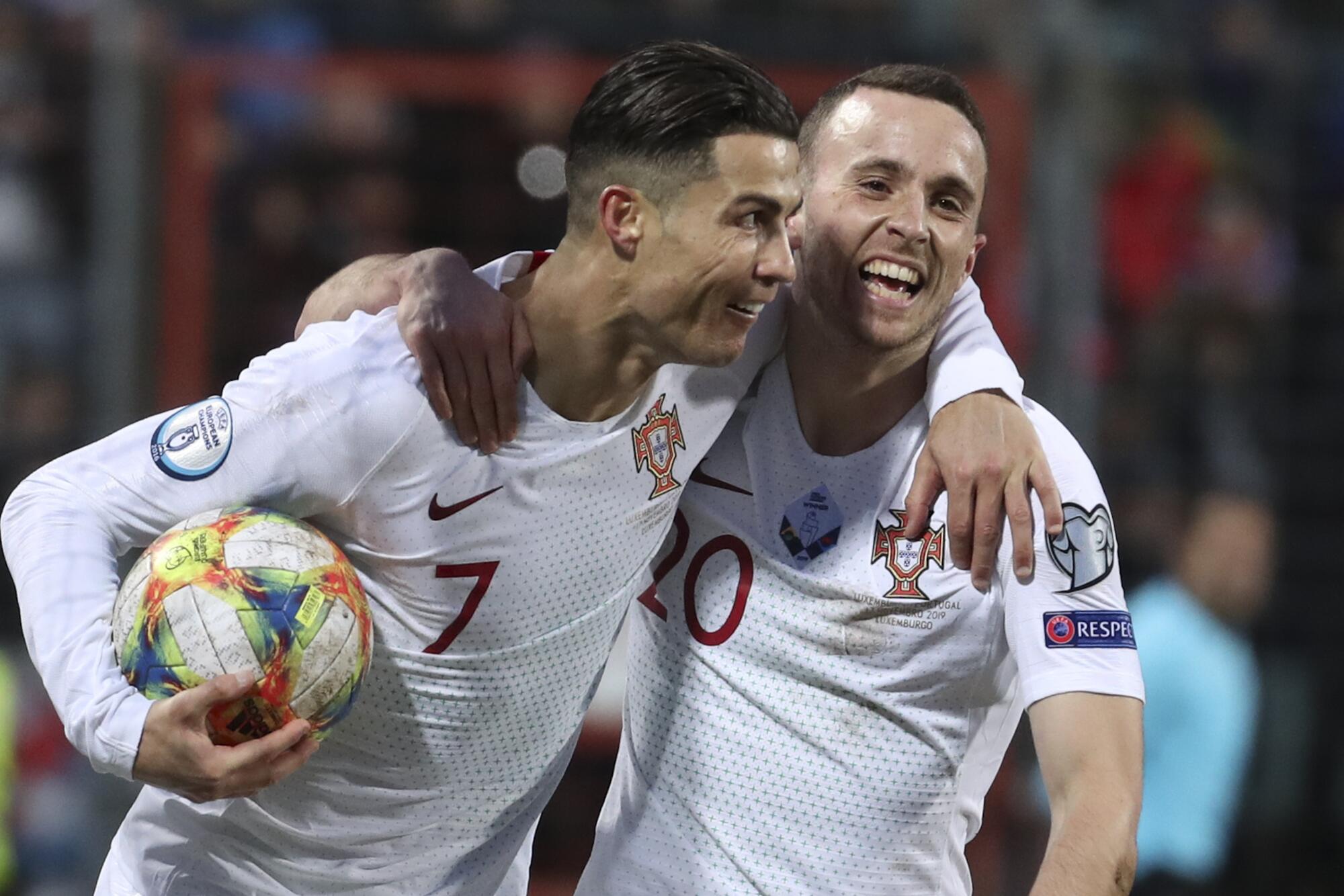 Cristiano Ronaldo (vľavo) oslavuje gól s rukou okolo portugalského spoluhráča Dioga Jotu