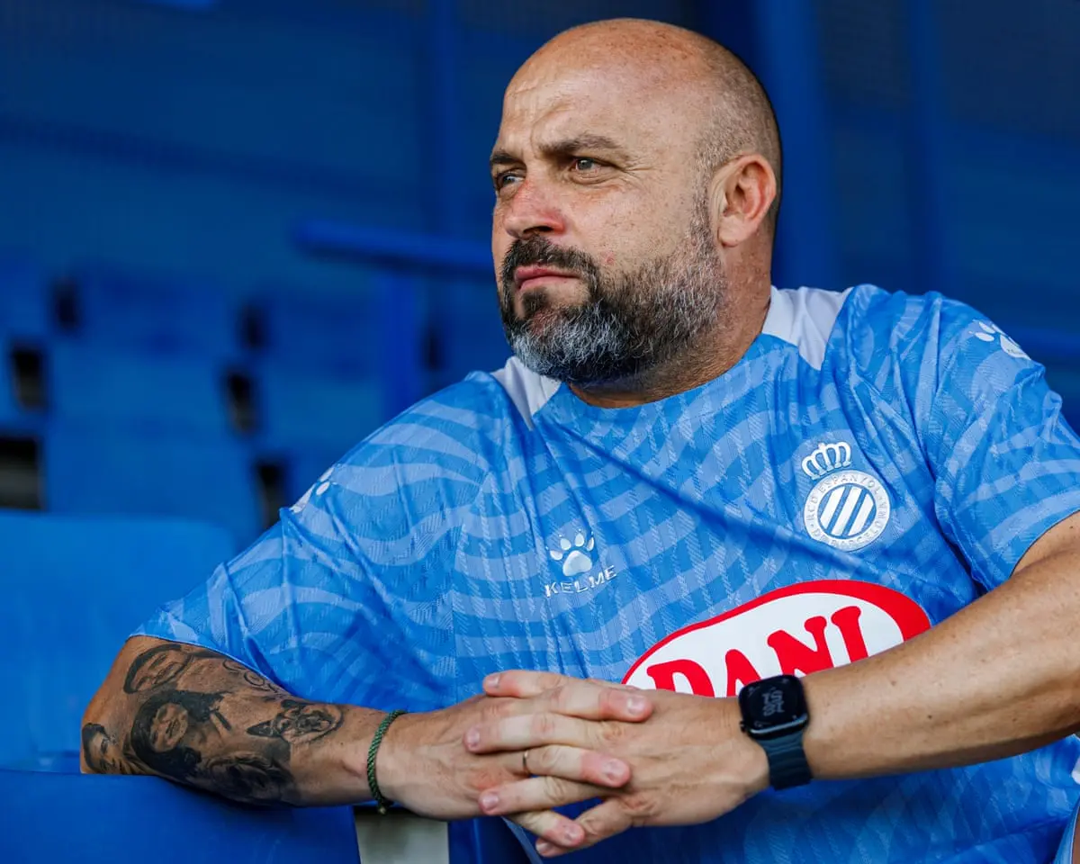Manolo Gonzalez Espanyol v modrom športovom drese sediaci na štadióne.