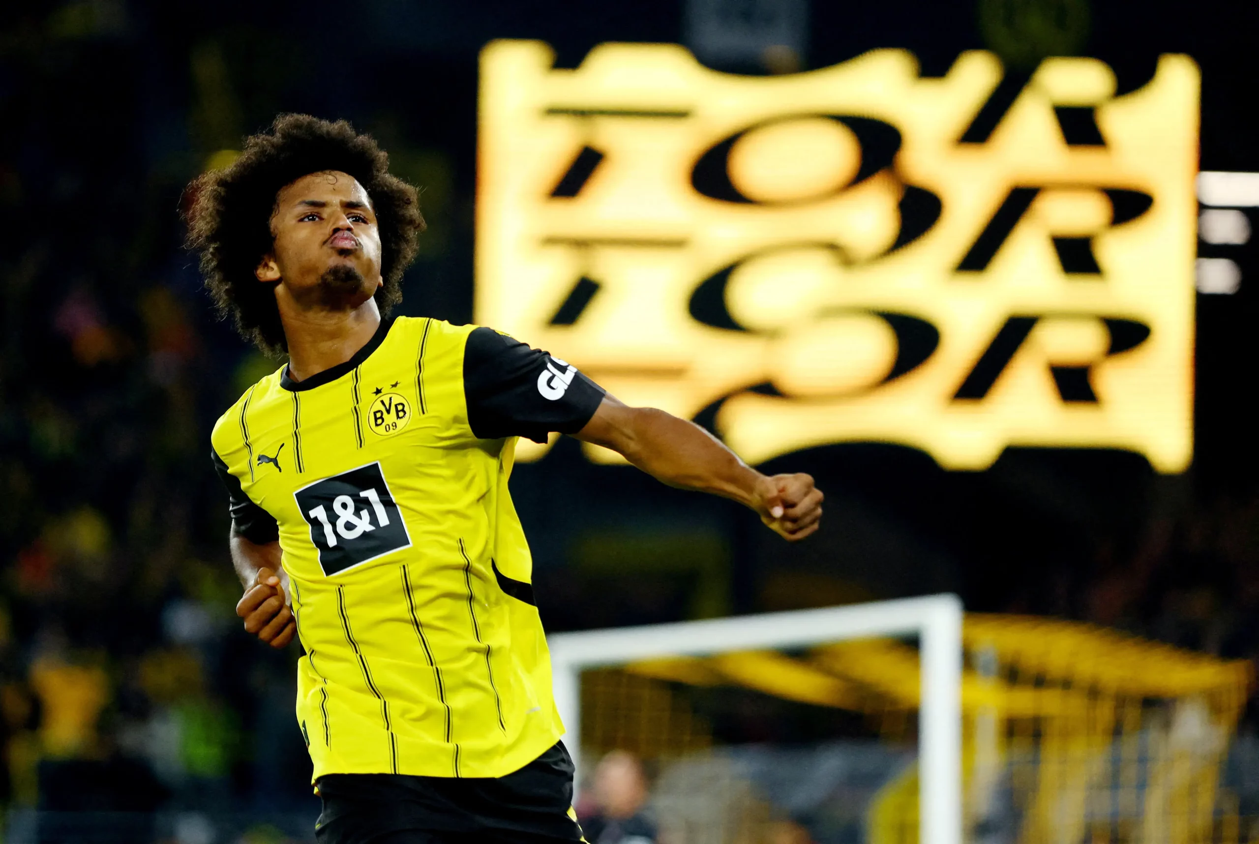 Karim Adeyemi oslavuje v žltom drese Borussie Dortmund počas zápasu.