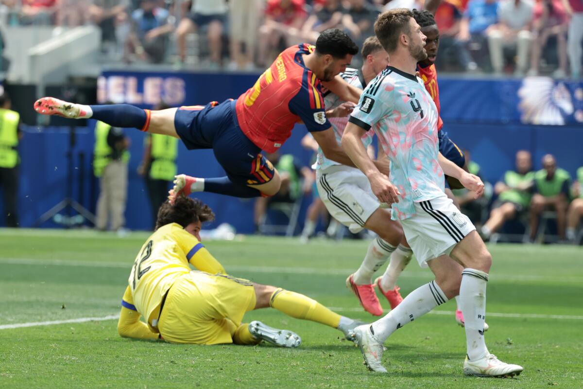 Španielsky stredopoliar Mikel Merino skóroval hlavou pred brankárom Belgicka Senne Lammensom.