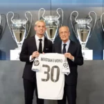 Franco Mastantuono drží dres Realu Madrid s trofejami v pozadí.