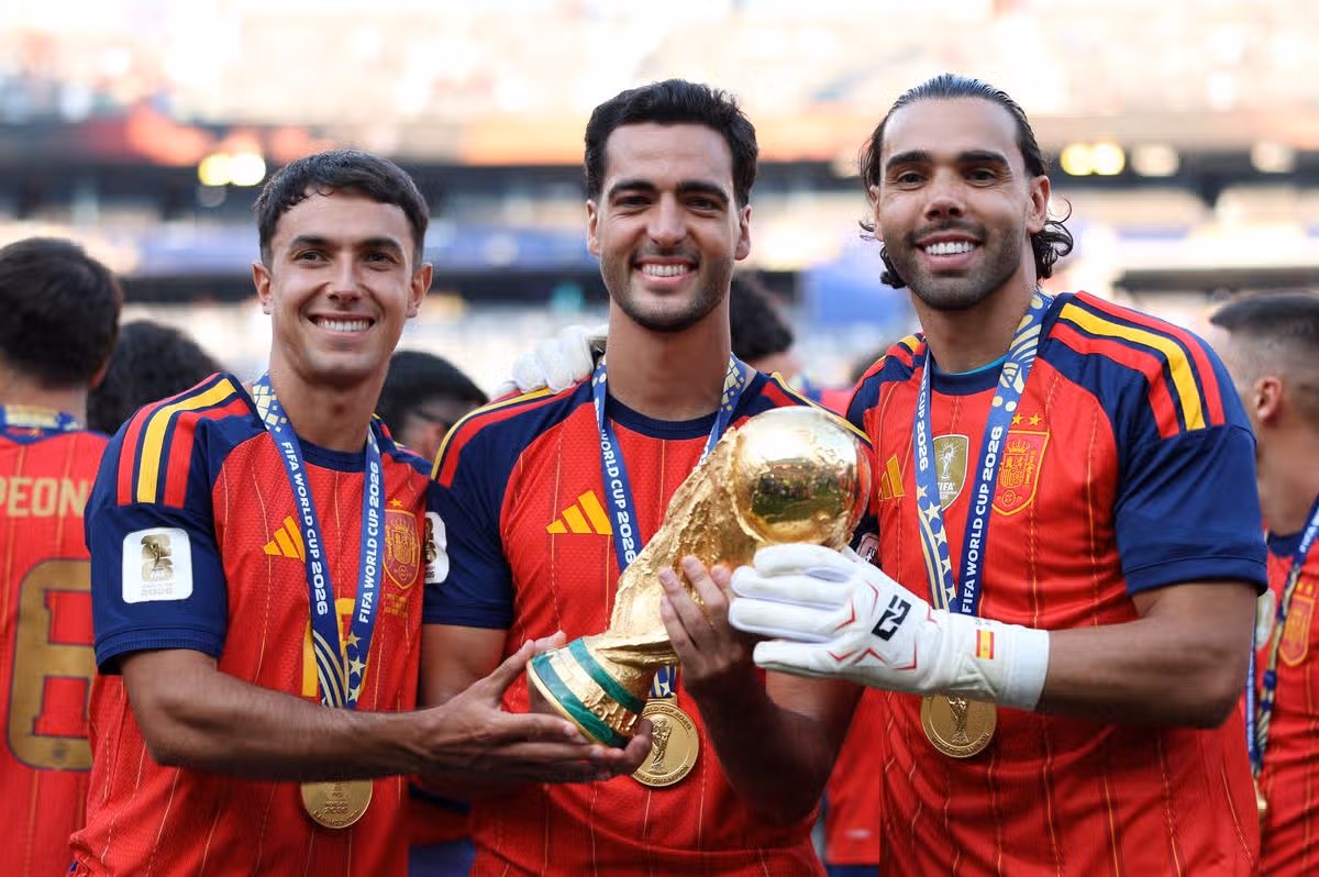 Martin Zubimendi #18, Mikel Merino #6 a David Raya #1 zo Španielska oslavujú s trofejou pre víťaza Svetového pohára FIFA po víťazstve tímu po finálovom zápase FIFA World Cup 2026 medzi Španielskom a Argentínou na štadióne New York New Jersey 19. júla 2026 v East Rutherford, New Jersey