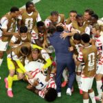 Americký tréner Mauricio Pochettino skáče svojim hráčom do náručia po víťazstve na majstrovstvách sveta nad Paraguajom.