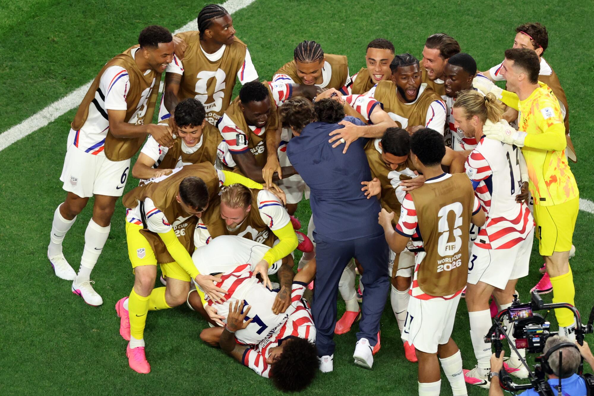 Americký tréner Mauricio Pochettino skáče svojim hráčom do náručia po víťazstve na majstrovstvách sveta nad Paraguajom.