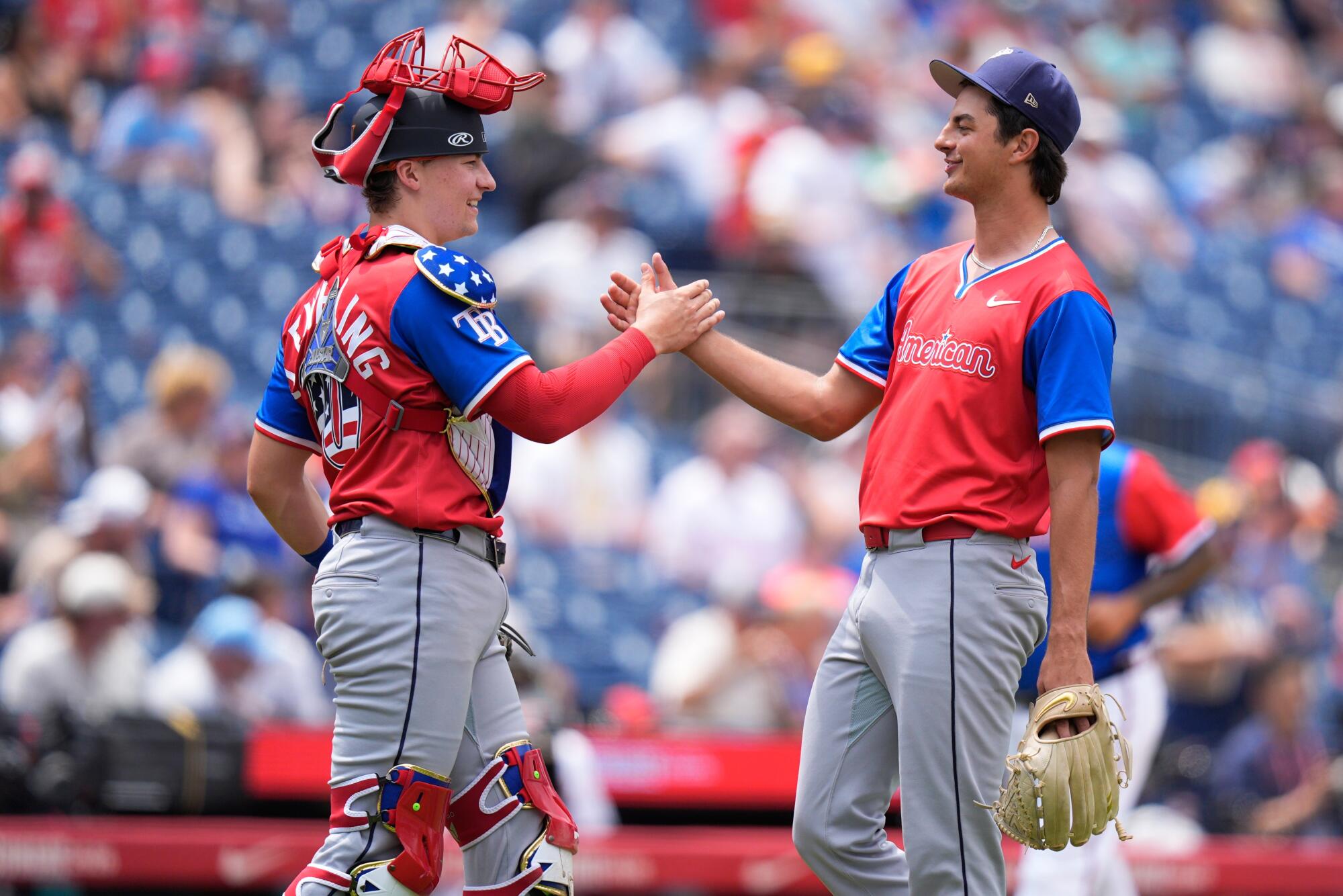 Chytač americkej ligy Nathan Flewelling víta nadhadzovača Tylera Bremnera počas zápasu MLB All-Star Futures.